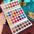 Makeup palette with a variety of colors held by a hand on a colorful background