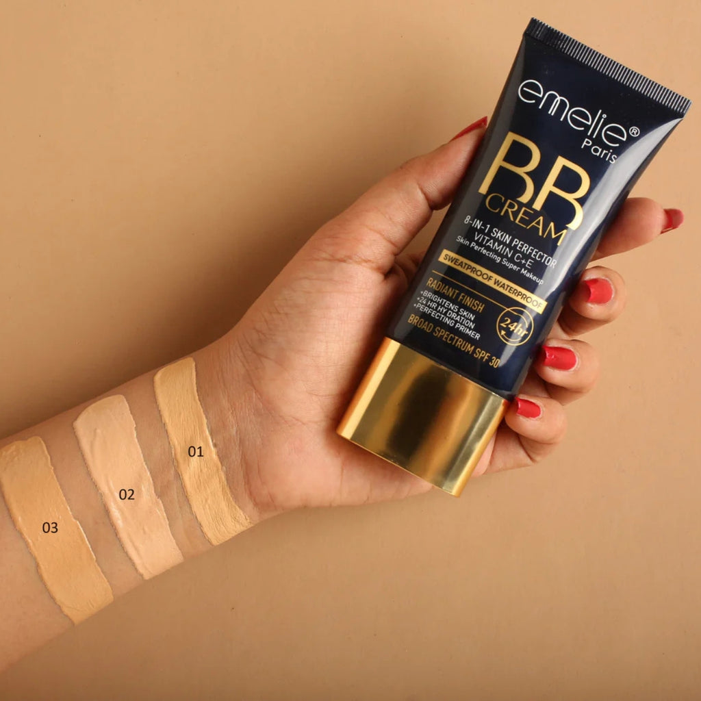 Hand holding a tube of Emelie Paris BB Cream with swatches on a beige background